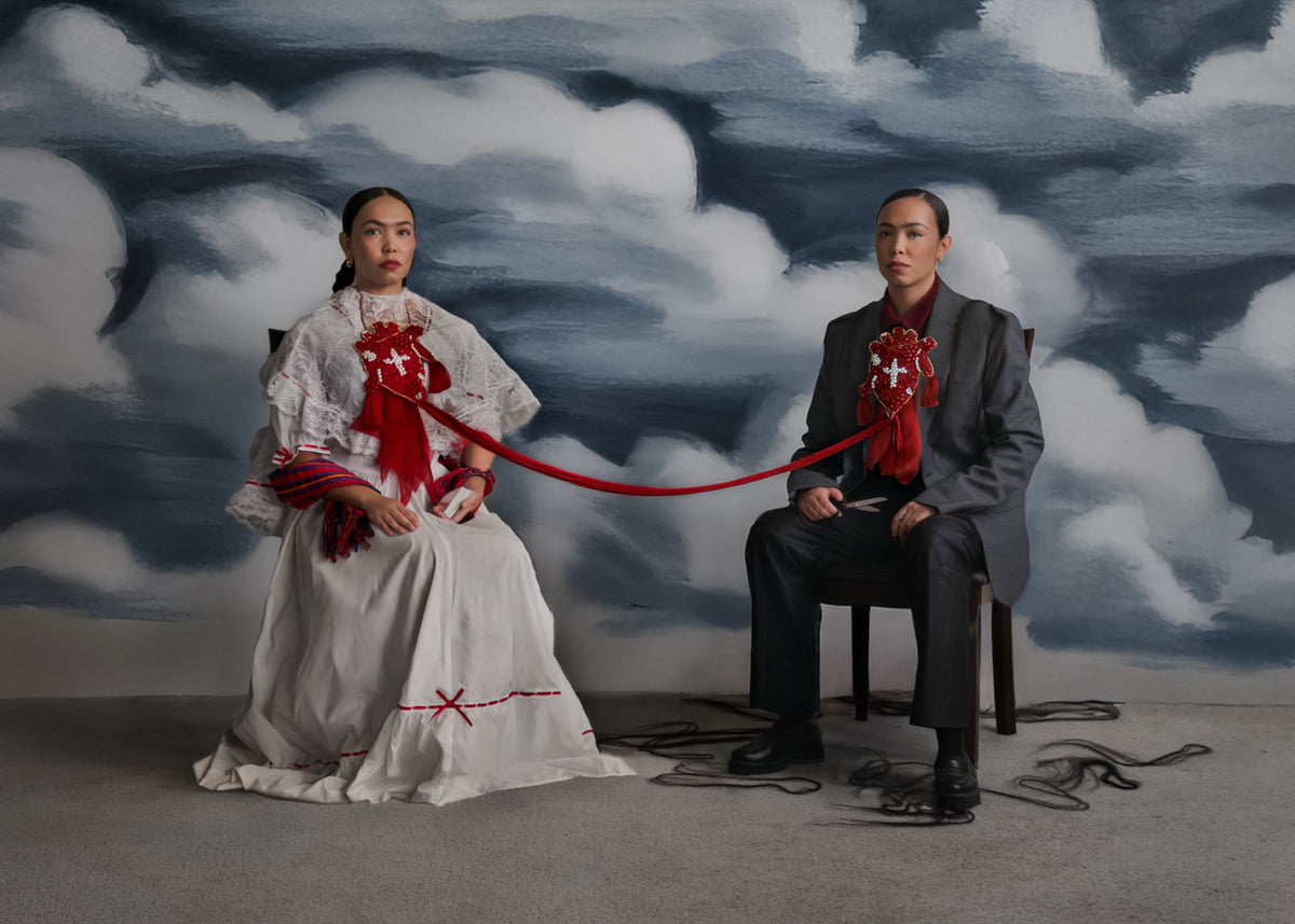 Two models posed before a cloud backdrop